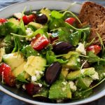 Delicious Greek salad featuring avocado, feta, and olives, ideal for a healthy meal.